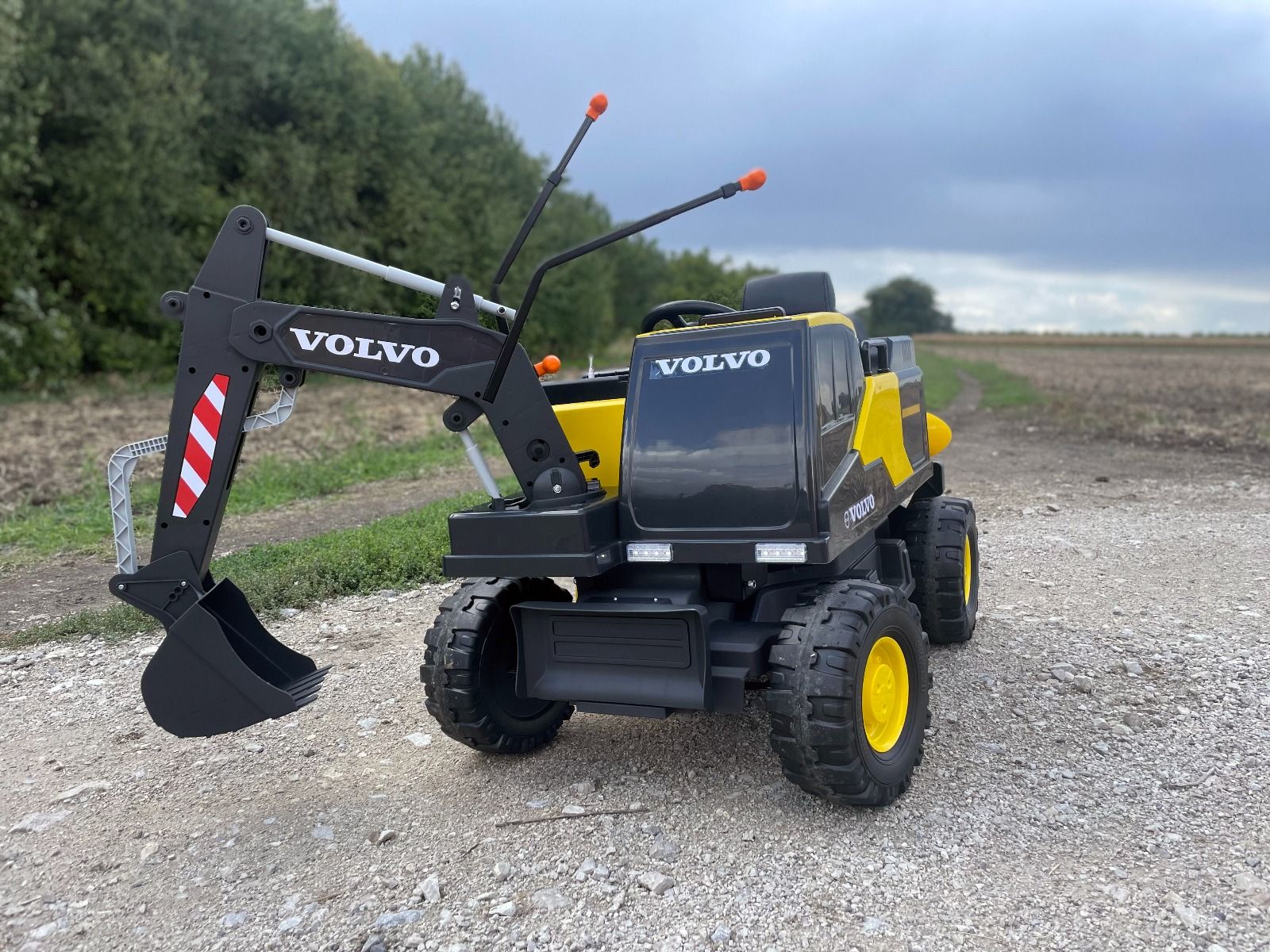 Elektrischer Bagger für Kinder Volvo Excavator 12V mit Baggerschaufel vorne, Einsitzer, gelb, weicher Kunstledersitz, MP3-Player mit USB/TF/AUX-Eingang, Heckantrieb, 2 x 35W Motor, EVA-Räder, 12V/14Ah Akku, lizenziert