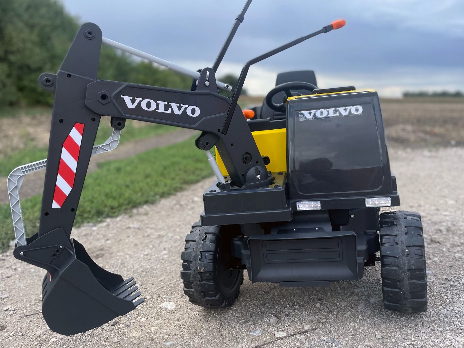 Elektrischer Bagger für Kinder Volvo Excavator 12V mit Baggerschaufel vorne, Einsitzer, gelb, weicher Kunstledersitz, MP3-Player mit USB/TF/AUX-Eingang, Heckantrieb, 2 x 35W Motor, EVA-Räder, 12V/14Ah Akku, lizenziert