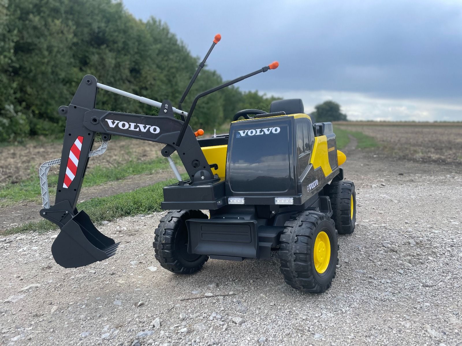 Elektrischer Bagger für Kinder Volvo Excavator 12V mit Baggerschaufel vorne, Einsitzer, gelb, weicher Kunstledersitz, MP3-Player mit USB/TF/AUX-Eingang, Heckantrieb, 2 x 35W Motor, EVA-Räder, 12V/14Ah Akku, lizenziert