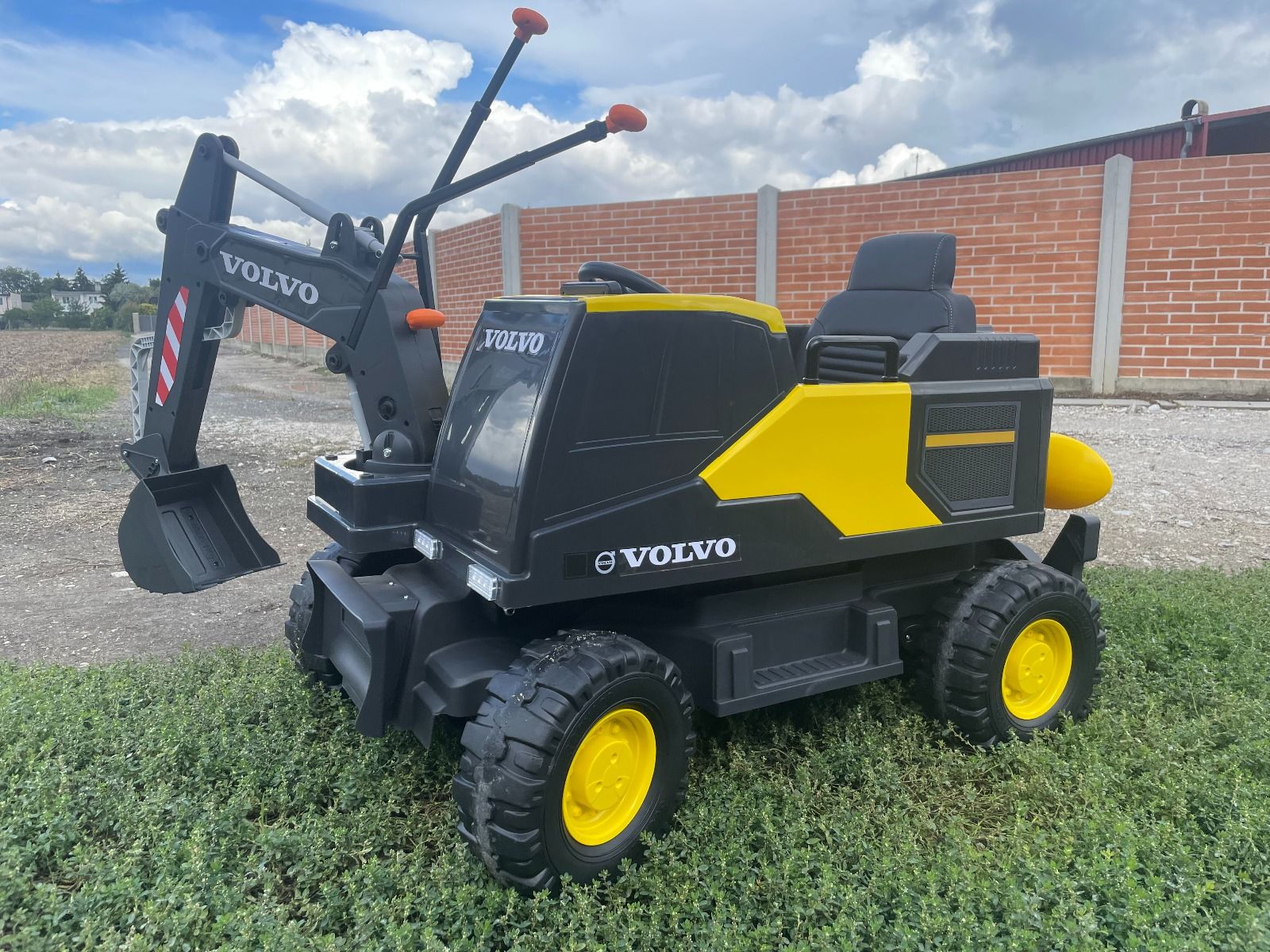 Elektrischer Bagger für Kinder Volvo Excavator 12V mit Baggerschaufel vorne, Einsitzer, gelb, weicher Kunstledersitz, MP3-Player mit USB/TF/AUX-Eingang, Heckantrieb, 2 x 35W Motor, EVA-Räder, 12V/14Ah Akku, lizenziert